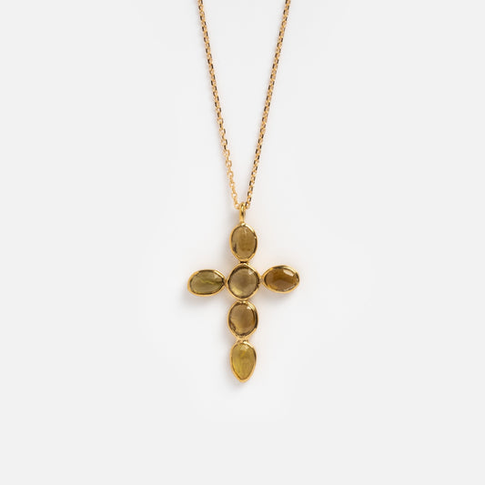 The Anika Chain Necklace features a gold chain with a cross pendant adorned with five oval, light amber stones in gold bezels—shown on a white background and inspired by Sophie Deschamps Bijoux’s elegant style.