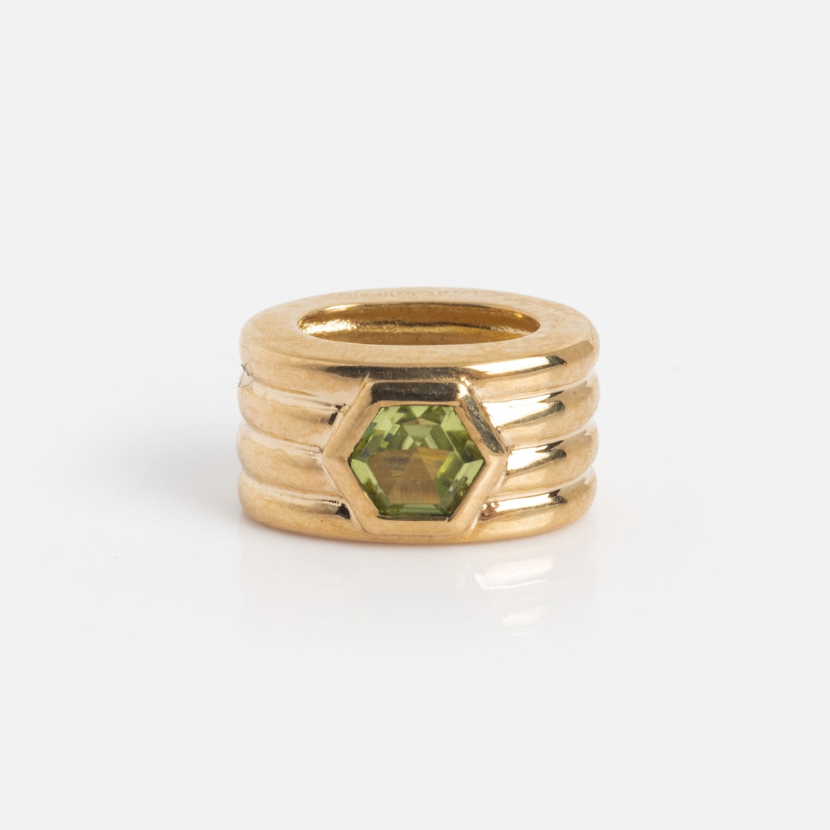 The Solid Gold Bold Birthstone Spacer Charm features four stacked bands and a hexagon-shaped green gemstone at the center, shown on a white background.
