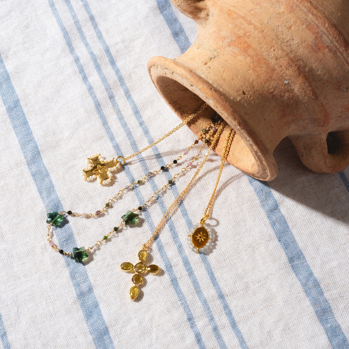 Marceau Necklace, Collier Bangalore Necklace, Karana Necklace and two other necklaces displayed spilling out of jug