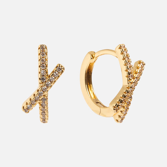 The Staci Huggies are yellow gold earrings with a crisscross design and sparkling CZ stones, shown against a plain white background.