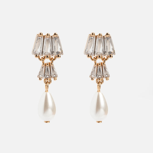 The Rue Drop Earrings feature three clear, trapezoid gemstones stacked above a dangling teardrop-shaped pearl in gold, perfect for fans of elegant Art Deco style.
