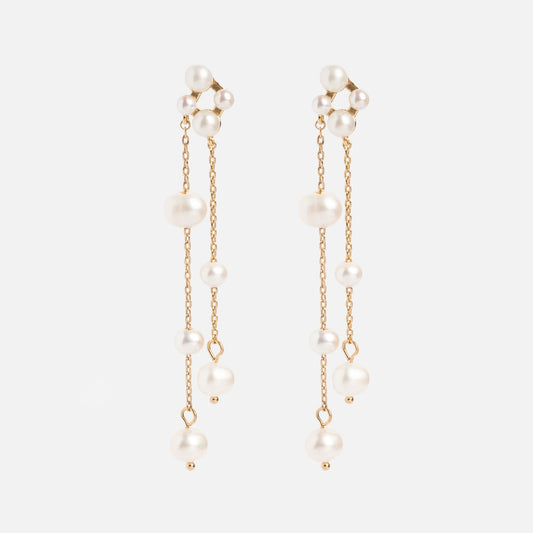 The Felicity Drop Earrings are gold plated with two delicate chains on each, adorned with small and medium freshwater pearls, displayed against a plain white background.