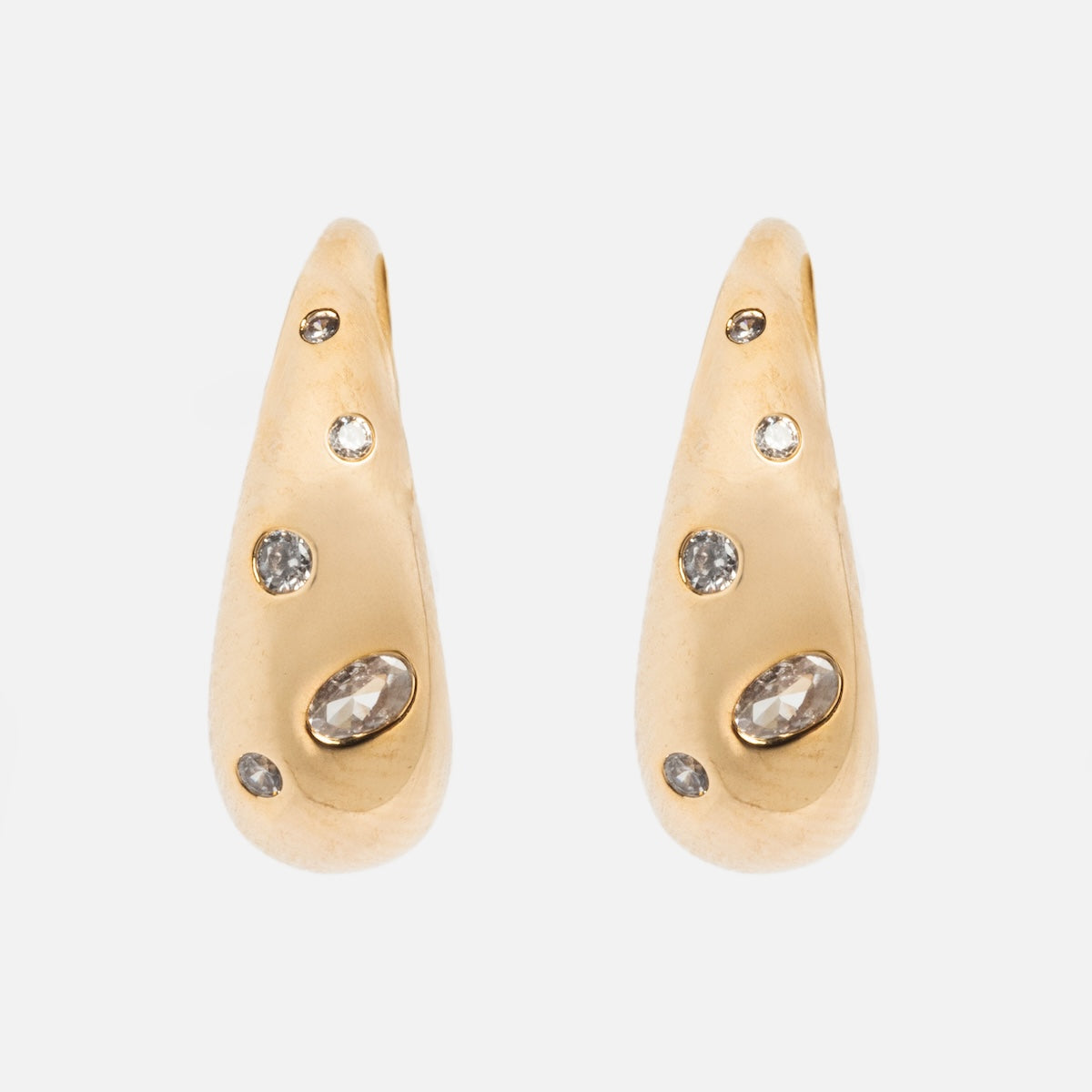 Golden Shimmer Tapered Hoop Earrings by Tai Jewelry, featuring multiple embedded clear gemstones in a teardrop shape, displayed against a plain white background.