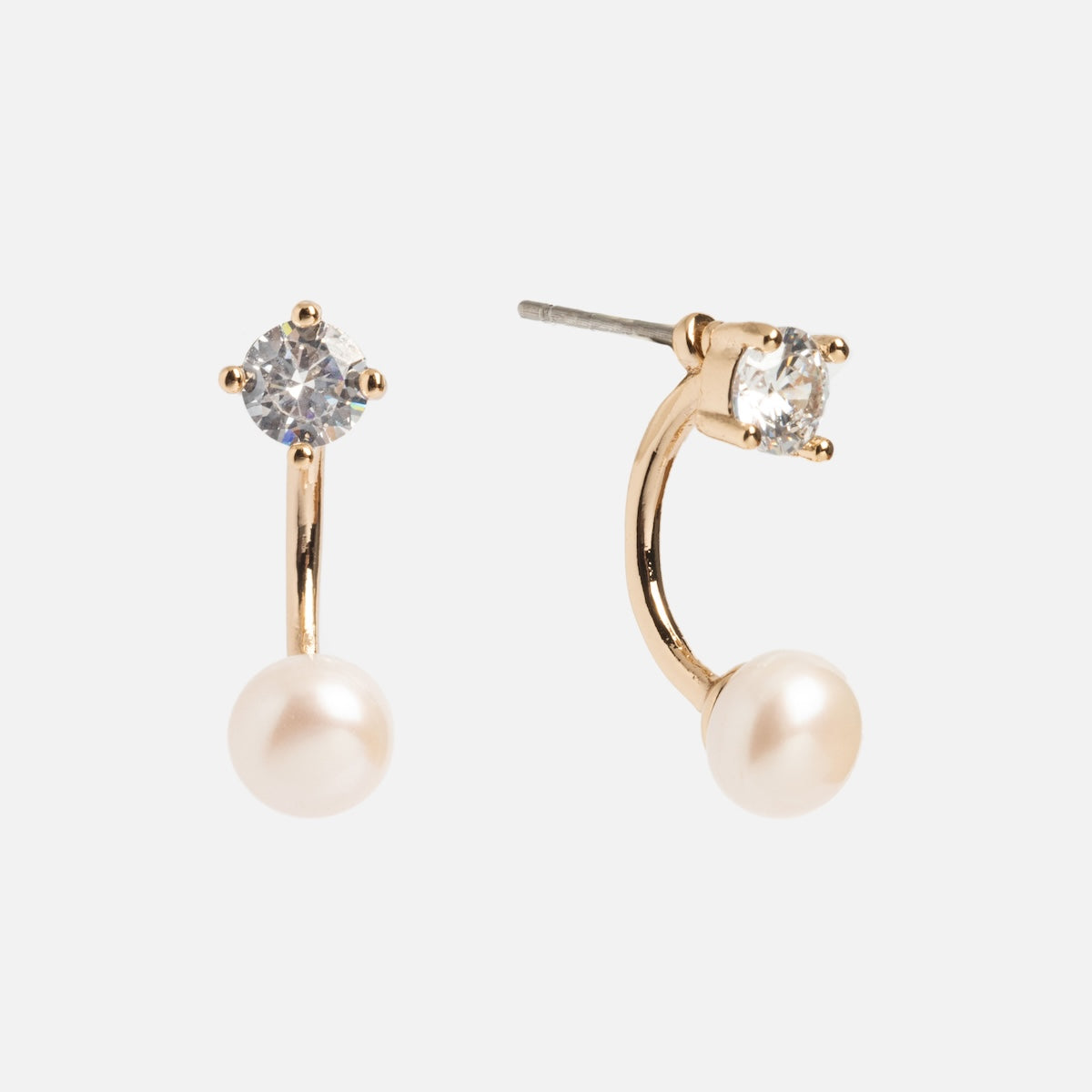 The Aria Earrings feature clear round gemstone studs with curved gold-plated drops ending in freshwater pearls. The photo displays one earring from the front and the other from the side.