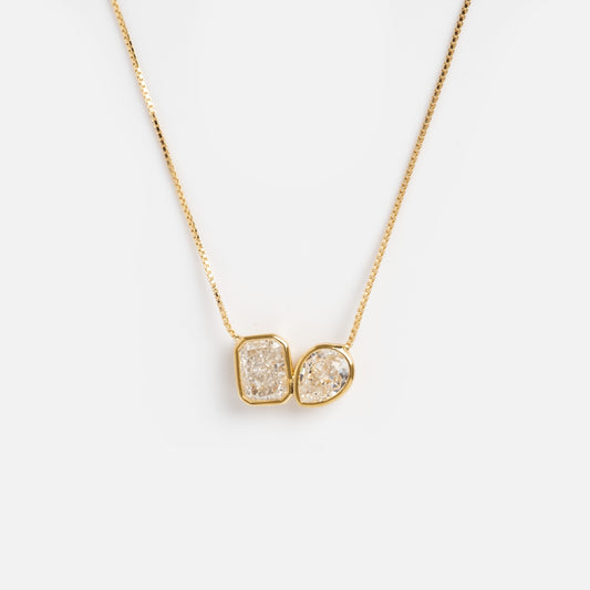The Baguette and Pear Cushion Pendant Necklace features a delicate Shashi 14k gold vermeil chain with two sparkling, uniquely shaped stone pendants, shown on a plain white background.