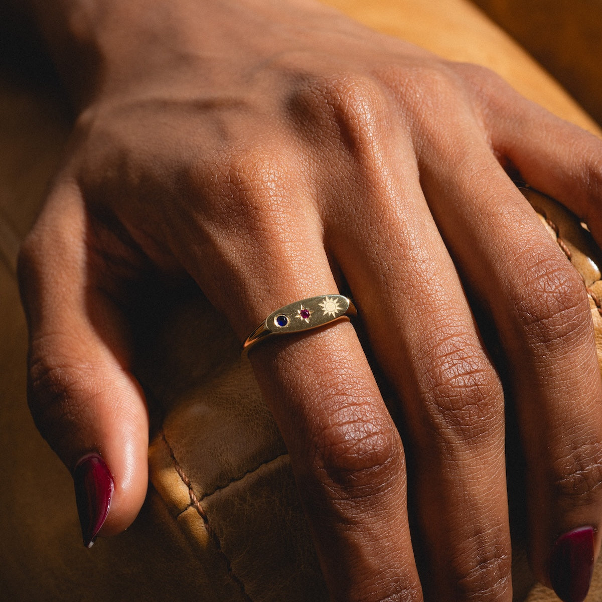 Close-up of a hand wearing a gold manifestation ring