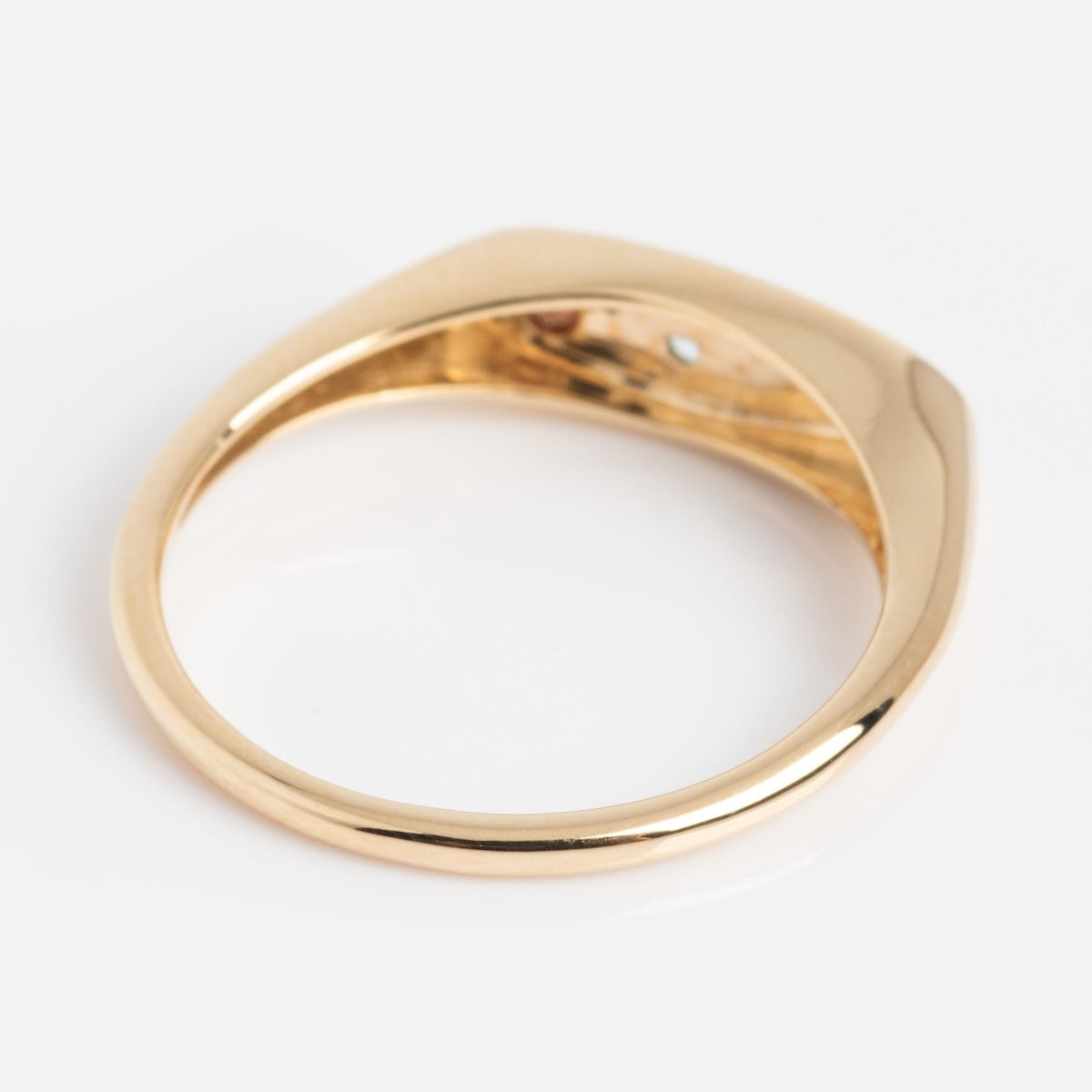 Back of gold manifestation ring on a white background