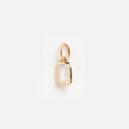 The Solid Gold Birthstone Baguette Charm June Sample is a small rectangular pendant with a clear, faceted stone set in gold and a gold loop, shown against a plain white background.
