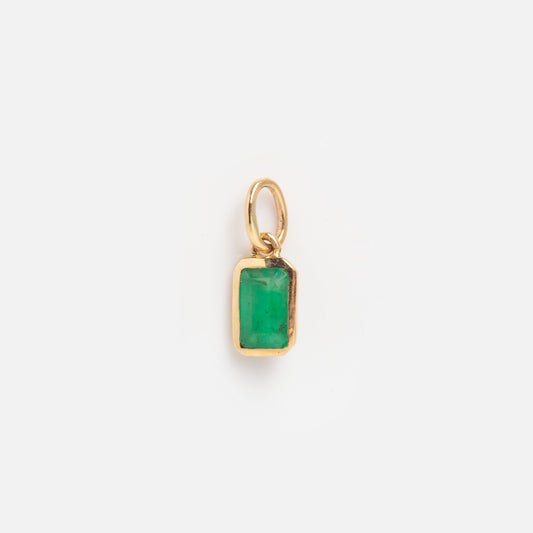 A Solid Gold Birthstone Baguette Charm for May featuring a rectangular green gemstone in a simple gold bezel pendant with a small loop for necklaces, displayed on a plain white background.