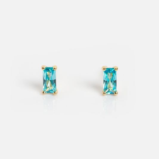 The Birthstone Baguette Studs March Sample features rectangular, emerald-cut blue gemstone studs set in gold prongs and displayed on a white background.