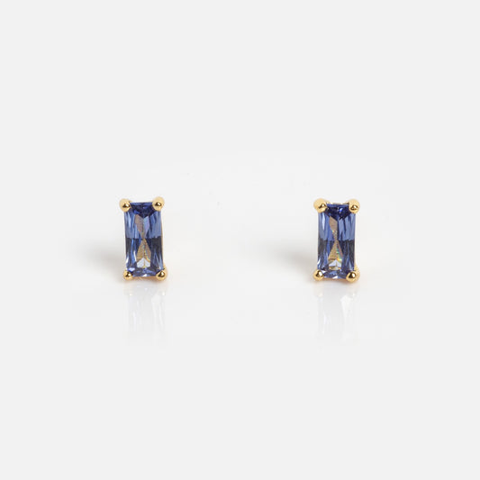 Birthstone Baguette Studs December Sample: rectangular blue gemstone studs set in gold prongs, shown on a plain white background.