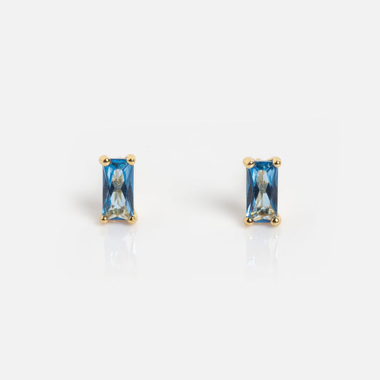 The Birthstone Baguette Studs September Sample features rectangular blue gemstone studs set in gold prongs, displayed on a white background.
