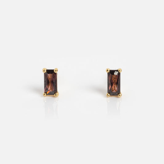 A pair of Birthstone Baguette Studs June Sample earrings with rectangular dark red stones set in gold prongs, shown on a plain white background.