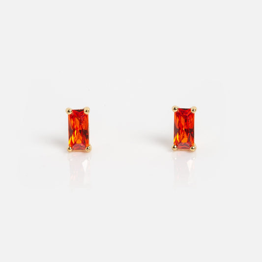 The Birthstone Baguette Studs January Sample are rectangular orange gemstone earrings set in gold prongs, shown on a plain white background.