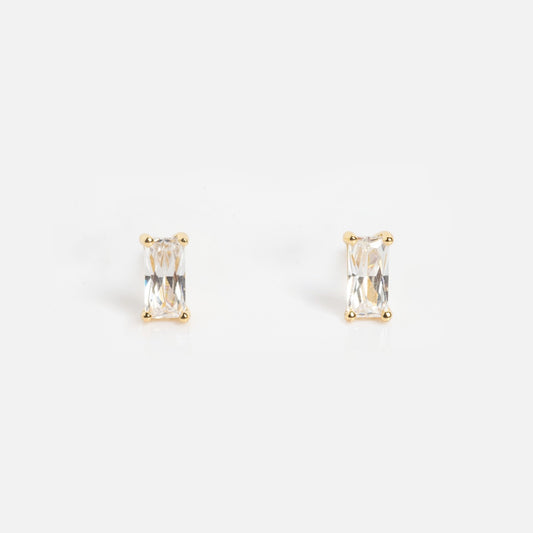 The Birthstone Baguette Studs April Sample features rectangular, clear gemstone studs set in gold prongs and is displayed against a plain white background.