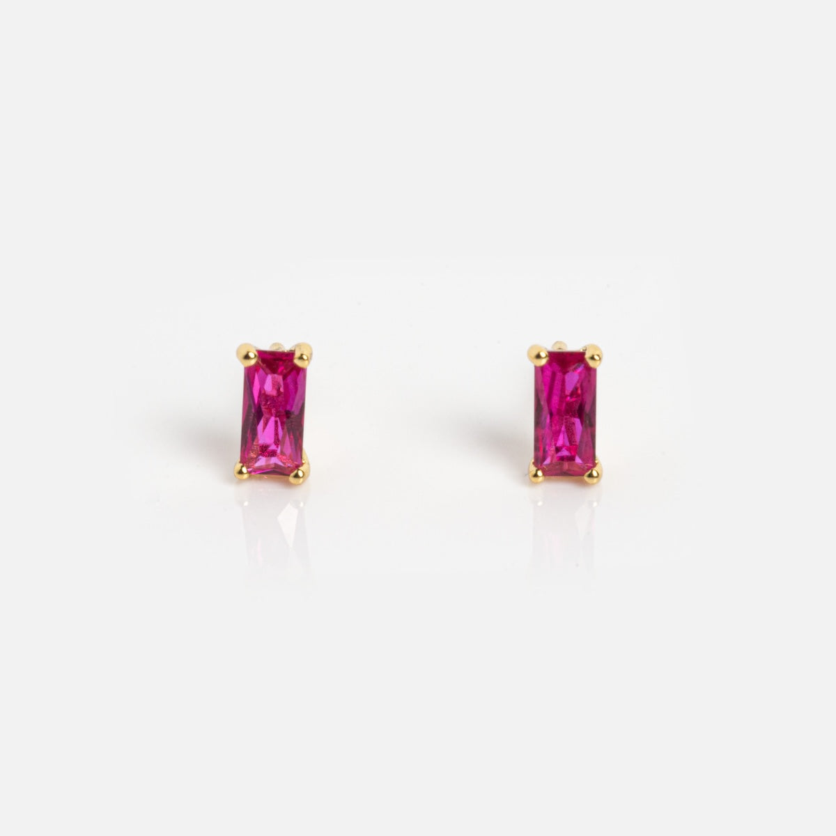 The Birthstone Baguette Studs July Sample features rectangular pink gemstone studs in gold prong settings, shown against a plain white background.