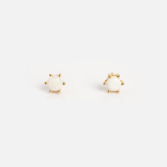 A pair of Solid Gold Hexagon Opal Stud Earrings Sample featuring round white opal stones set in gold, each secured by four prongs and displayed on a plain white background.