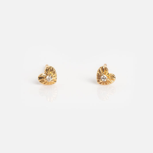 The Solid Gold Heart Stud Earrings Sample features small heart-shaped studs with a textured gold finish and a central clear gemstone, beautifully displayed on a white background.