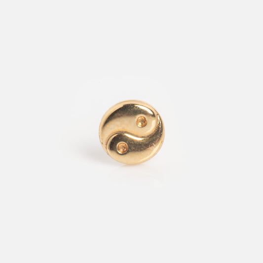 The Solid Gold Ying Yang Single Stud Earring Sample is a small, round gold stud with a yin-yang design and two gems, shown on a plain white background.