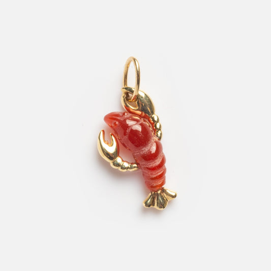 The Solid Gold Lobster Charm Sample is a small, red lobster-shaped charm featuring gold-colored claws, tail, and detailing, attached to a gold loop for hanging. Displayed against a plain white background.