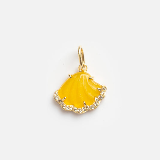 The Yellow Shell Charm Sample is a gold pendant in a scallop shell shape with a bright yellow center and a border of sparkling crystals, set on a plain white background.