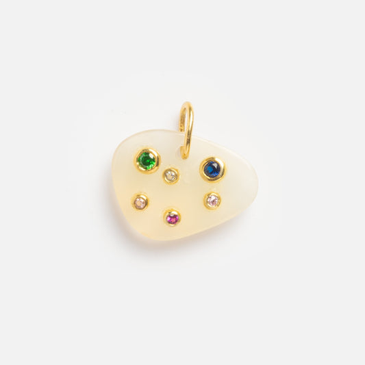 The White Chalcedony Capricorn Constellation Charm Sample is a gold-edged, irregular white pendant adorned with six colorful gemstones—green, blue, pink, and clear—in a scattered constellation-inspired pattern.