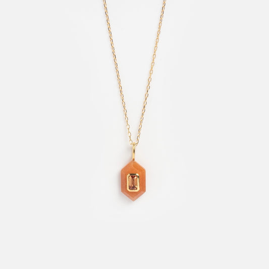 The Solid Gold Large Aura Necklace Orange Sample features a gold chain with a hexagonal pendant and a small rectangular orange gemstone at its center, displayed against a plain white background.