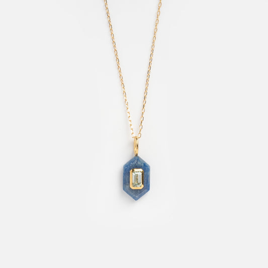 The Solid Gold Large Aura Necklace Blue Sample features a hexagonal blue pendant with an emerald-cut gemstone at the center, shown against a plain white background.