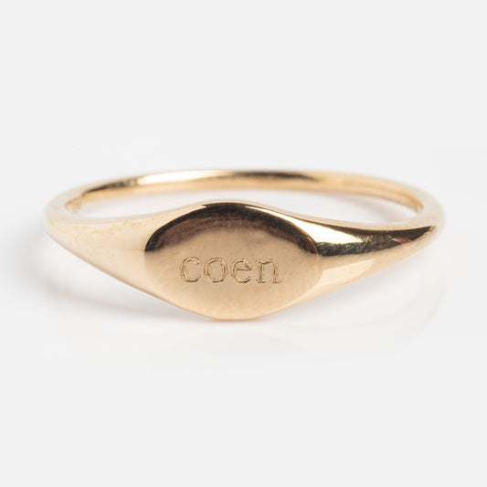 A simple 9k solid yellow gold signet ring, sample size 7, engraved with COEN on its oval face. The Solid Gold Engravable Simple Signet Ring is shown against a white background.