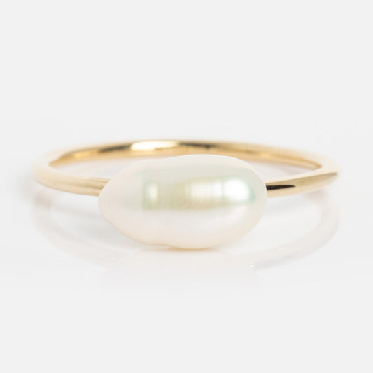 The Solid Gold Organic Pearl Solitaire Ring features a single, uniquely shaped white pearl centerpiece and is displayed against a white background.