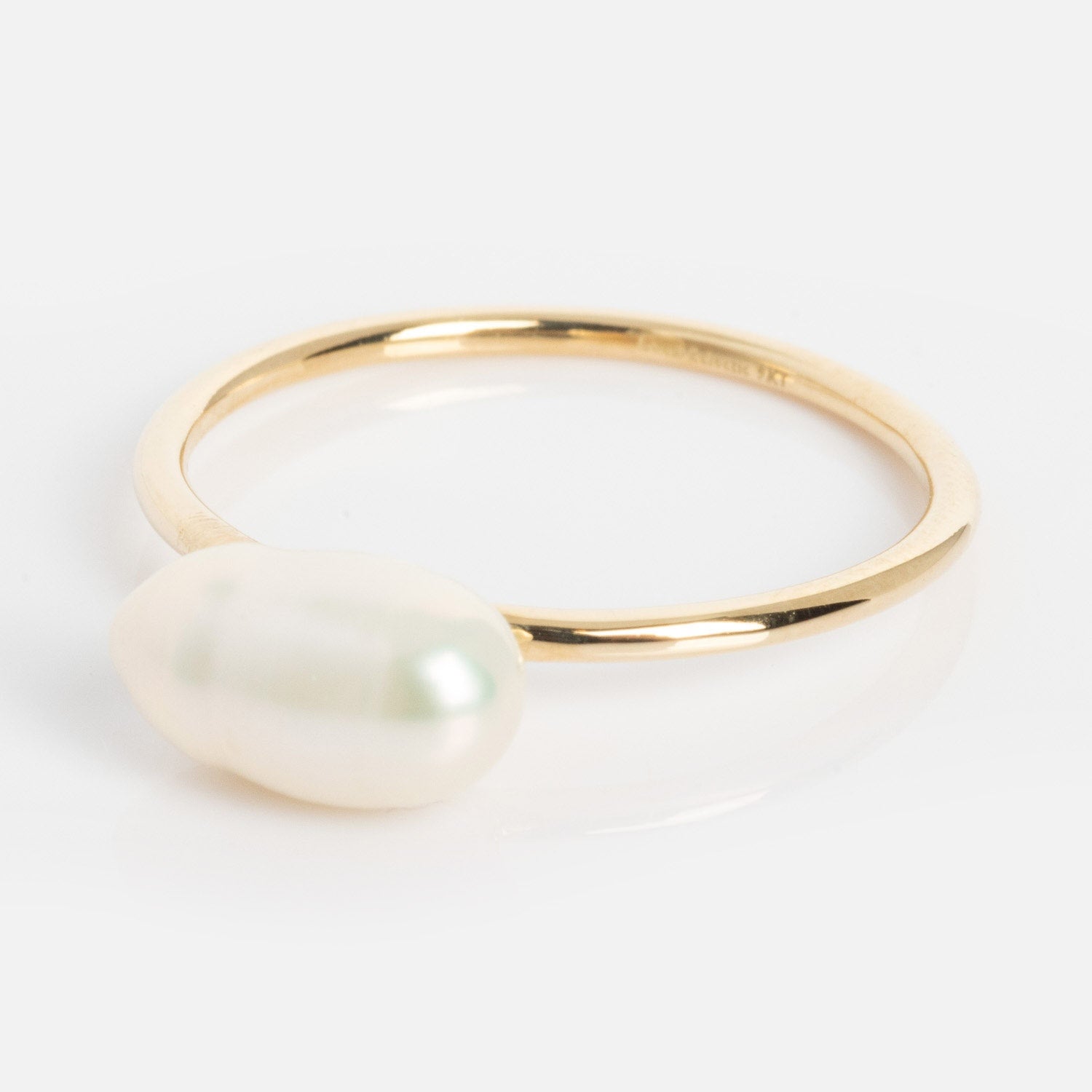 The Solid Gold Organic Pearl Solitaire Ring features a single horizontally set oval white pearl atop a slim gold band, shown on a white background.