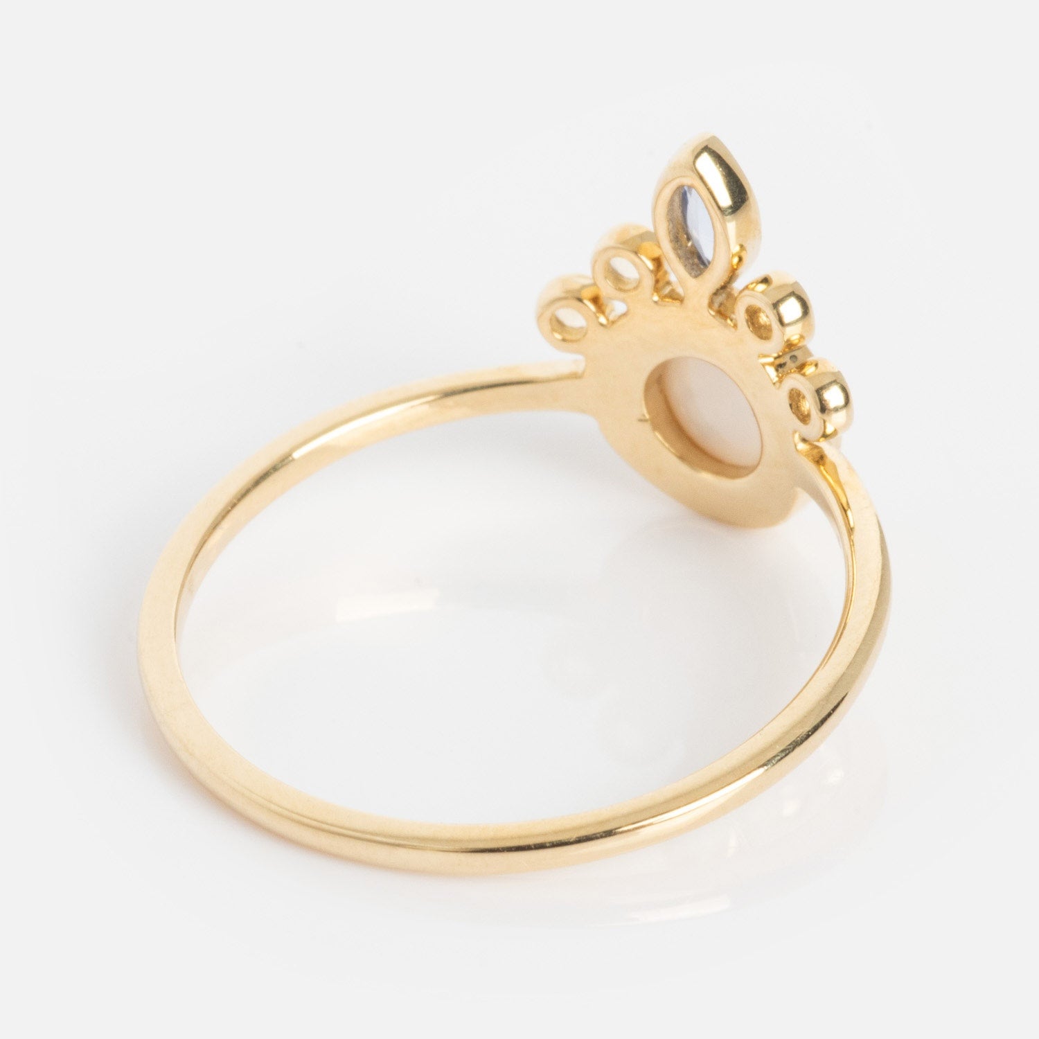 The Solid Gold Crowned Bezel Pearl Ring features a delicate crown-shaped design with ornate cut-out details and marquise accents, showcased against a white background.