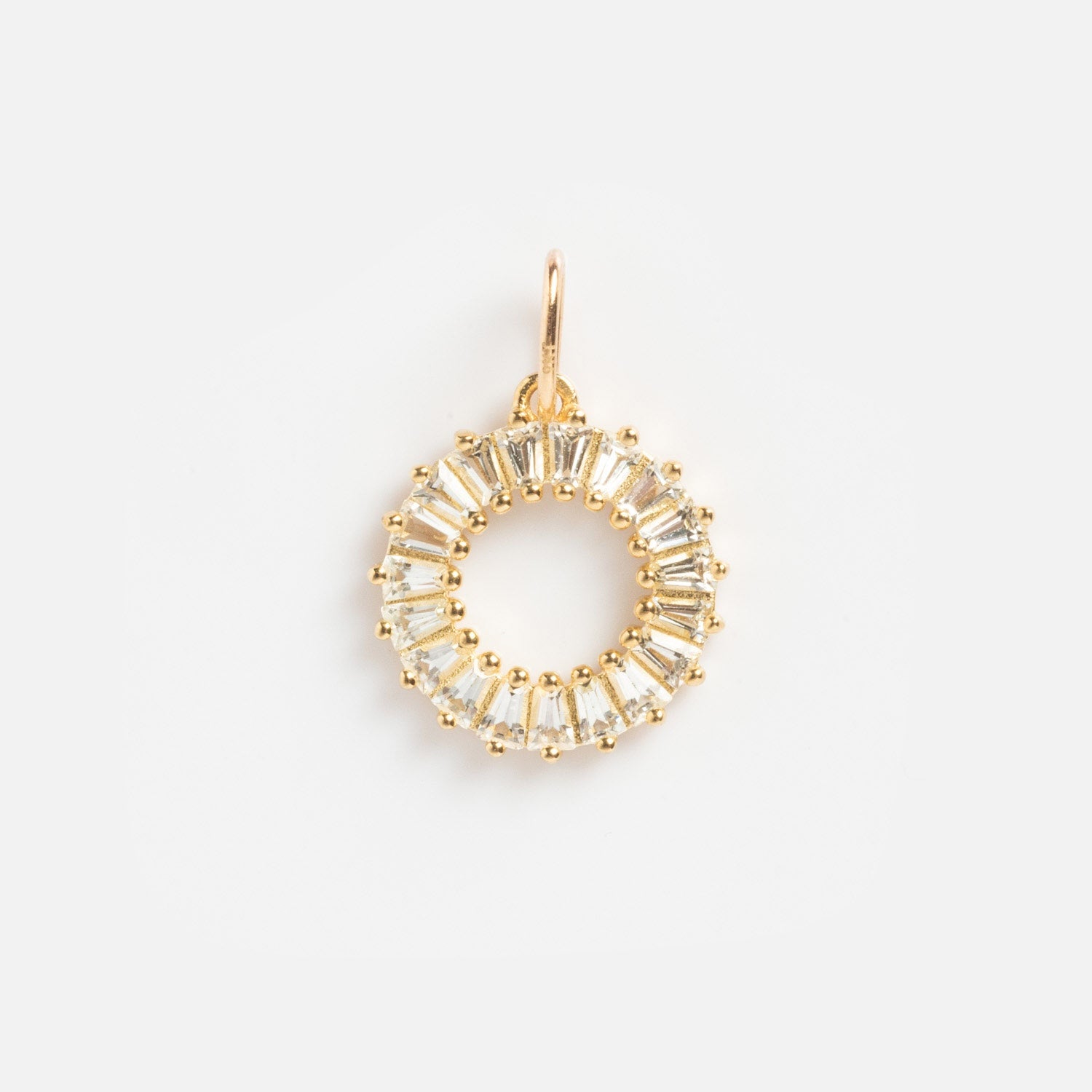 The Solid Gold Statement Charm is a circular gold pendant with evenly spaced clear baguette-cut gemstones, forming a striking ring shape and featuring a small gold loop for easy attachment to your favorite necklace.