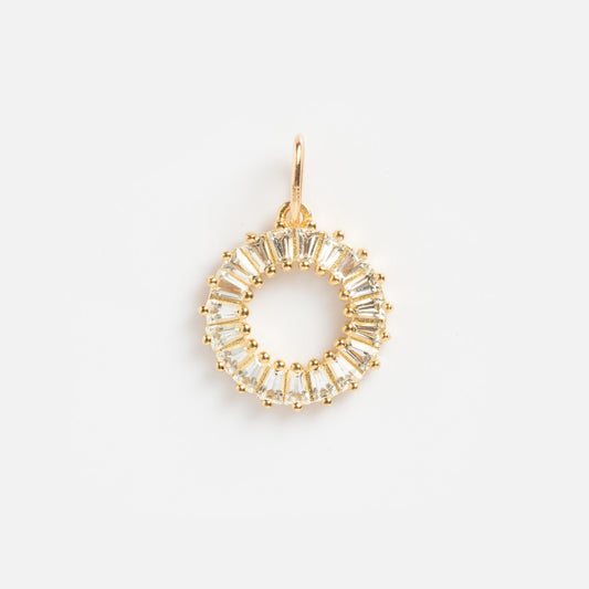 The Solid Gold Statement Charm is a circular gold pendant with evenly spaced clear baguette-cut gemstones, forming a striking ring shape and featuring a small gold loop for easy attachment to your favorite necklace.