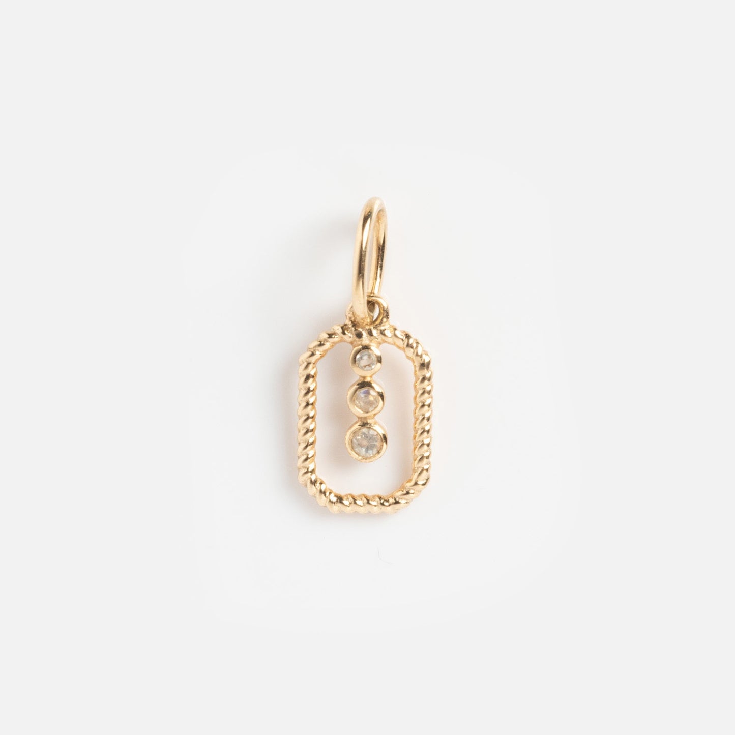 The Solid Gold Statement Charm is a unique necklace with a gold oval pendant, twisted rope border, and three small round gemstones hanging vertically, shown against a plain white background.