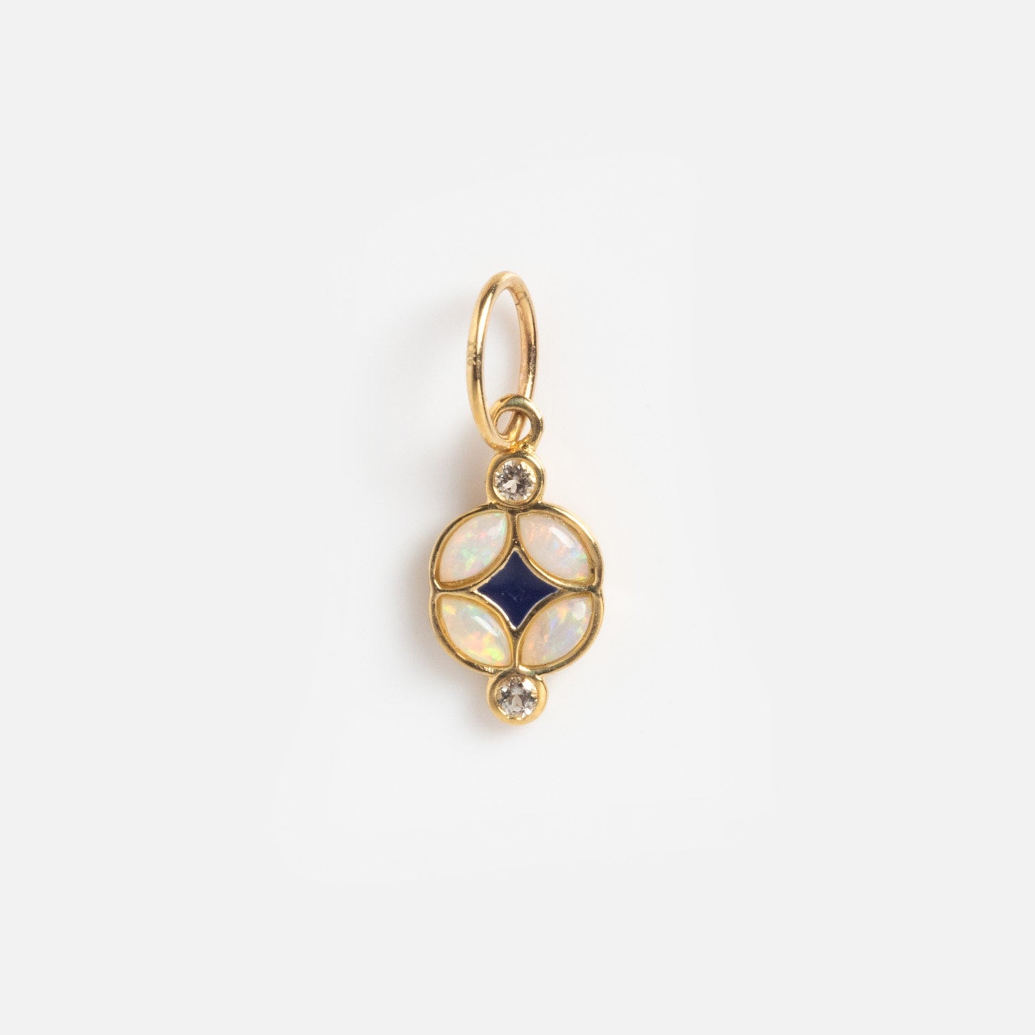 The Solid Gold Statement Charm is a round pendant with four iridescent opal-like stones circling a dark blue center, plus two small clear gems above and below—perfect for those who love unique, eye-catching jewelry.