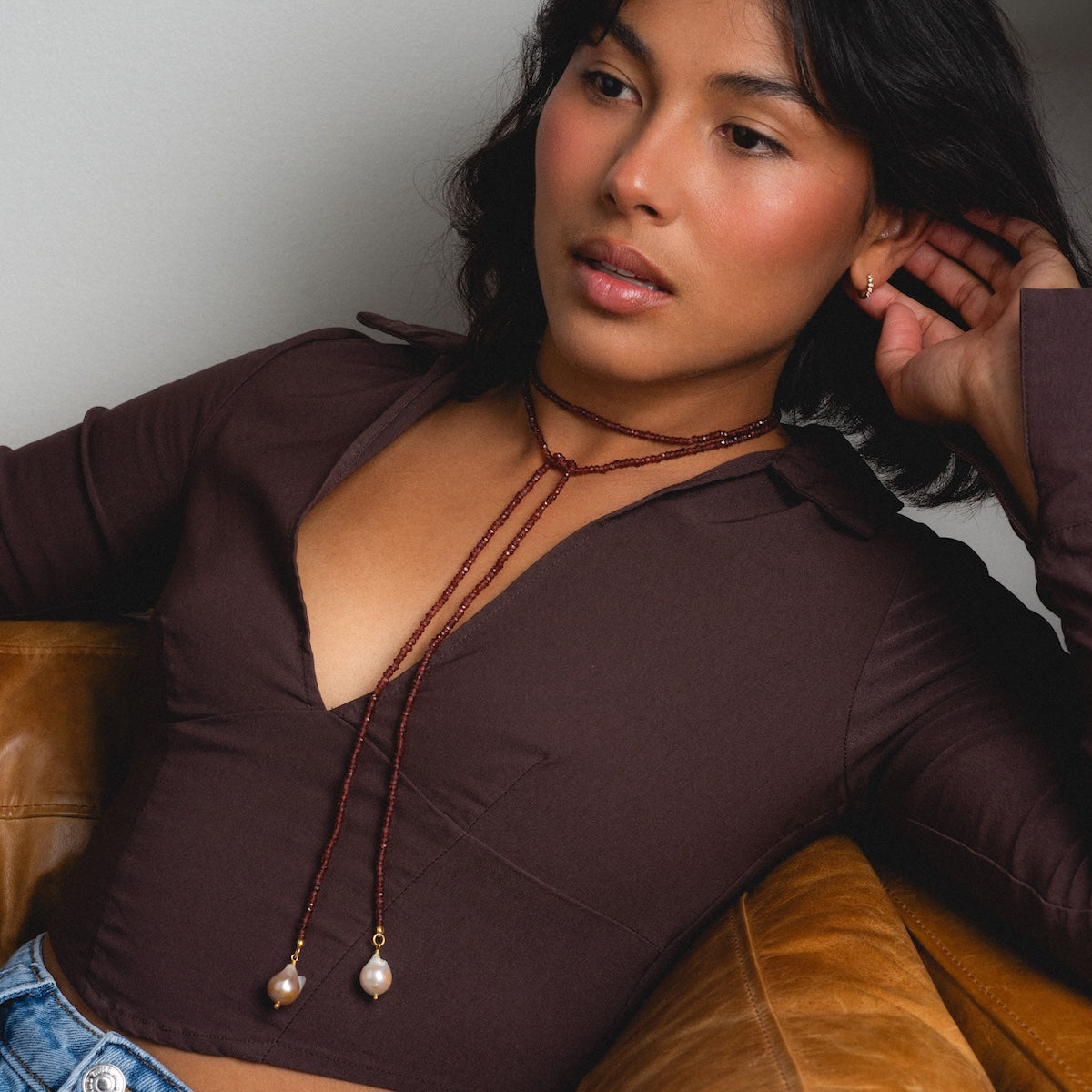 Woman wearing beaded garnet tie necklace with pearls