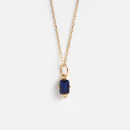 The Solid Gold 2025 September Capsule Classic Blue Sapphire Pendant Necklace features a rectangular lab-created blue sapphire set in a 9k yellow gold frame, shown against a plain white background.