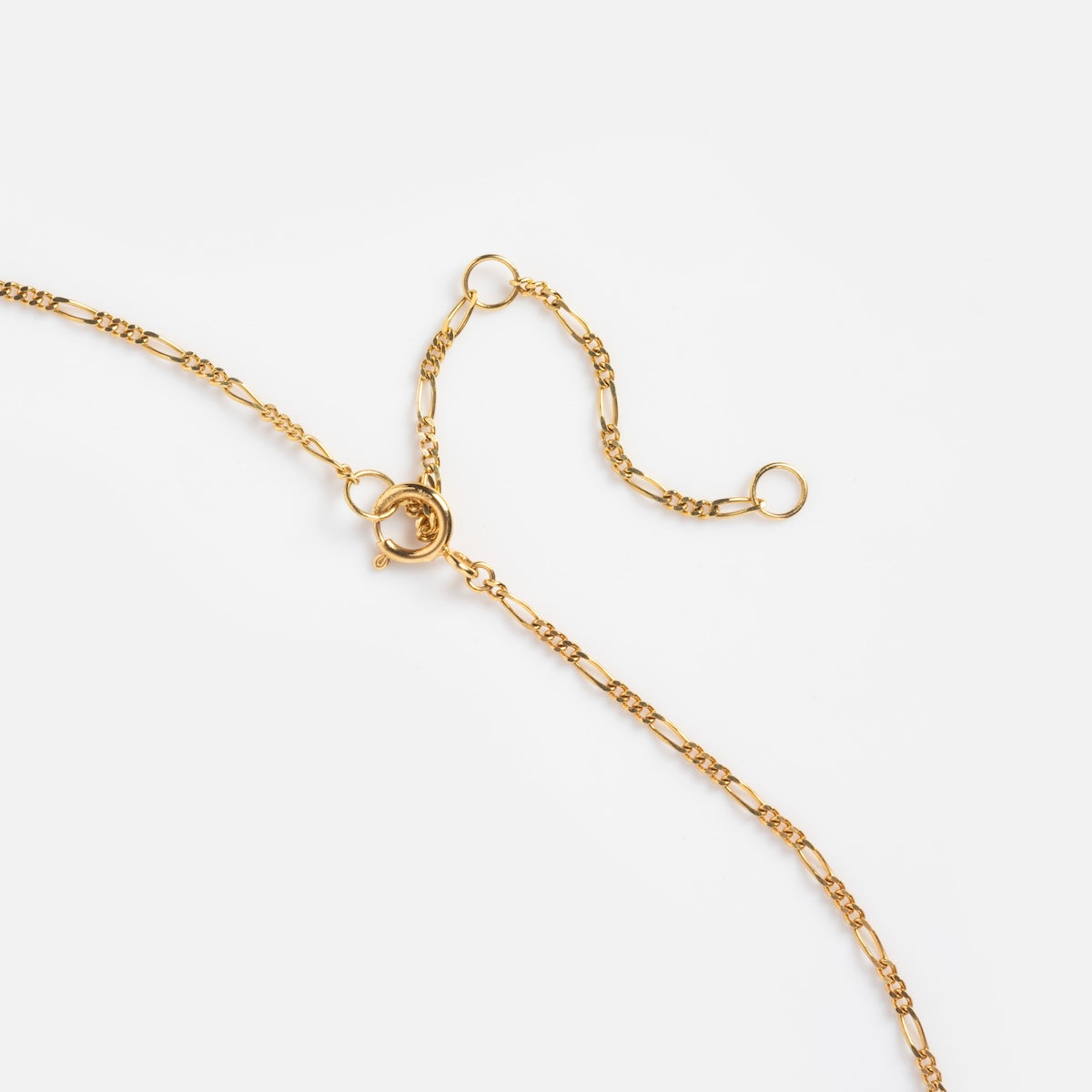 The Solid Gold Figaro Charm Holder Necklace features a delicate gold chain with a round spring clasp and two open jump rings, displayed on a plain white background.