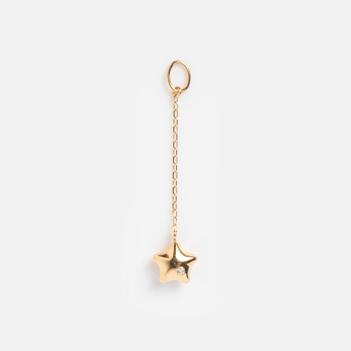 The Solid Gold Statement Charm features a star-shaped gold pendant with a small gemstone, suspended from a delicate gold chain and circular loop—ideal for those seeking standout solid gold jewelry. Shown on a plain white background.