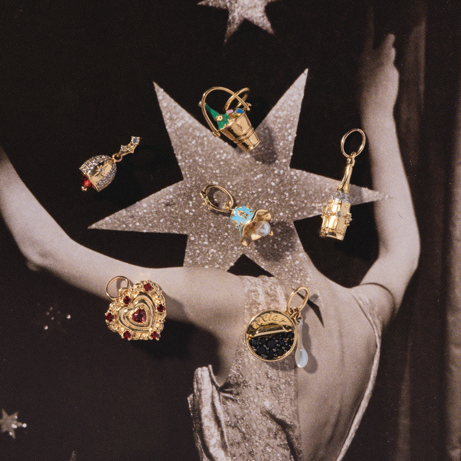 Six ornate Solid Gold Celebration Charms, featuring hearts, gemstones, and a small ship, are showcased on a vintage-style photo of someone in a sparkling dress with a star pattern on the back.