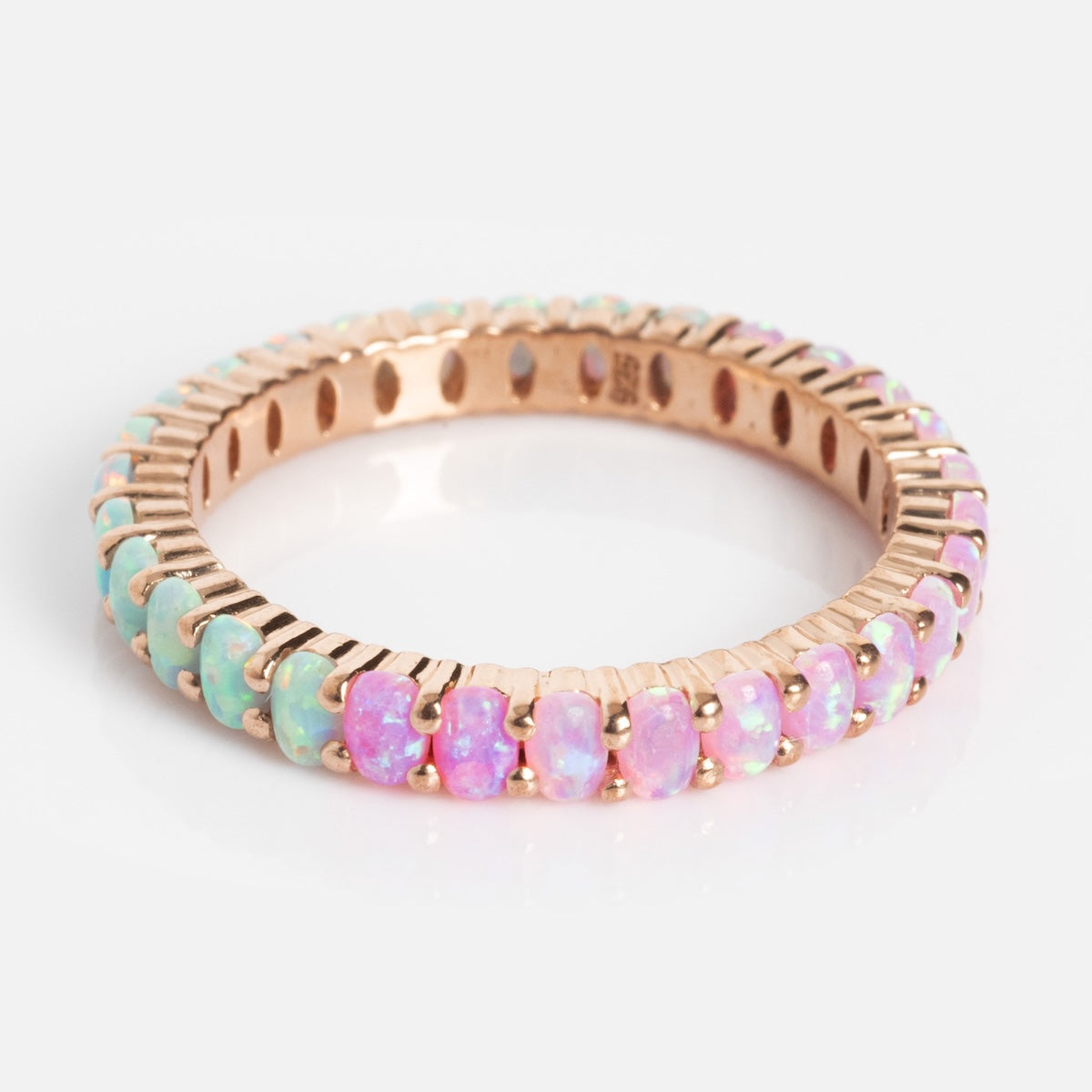 The Opal Ombre Dual Band features a gold eternity band adorned with oval opals in green, blue, and pink ombre hues, shown on a white background.