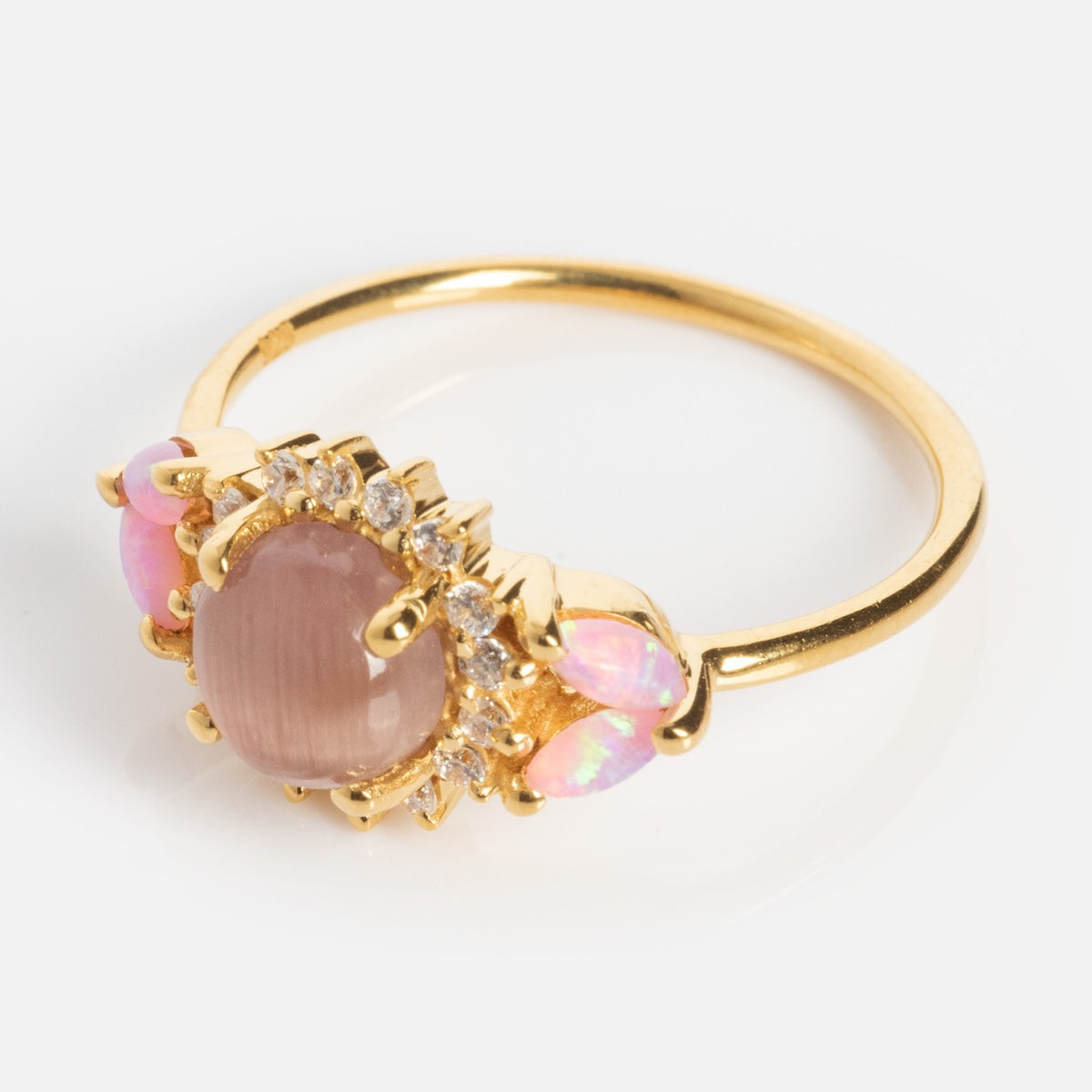 The Pink Opal and Cat's Eye Moonstone Sunflower Ring features a central round mauve stone, pink opals, and clear accent stones, showcased on a white background.