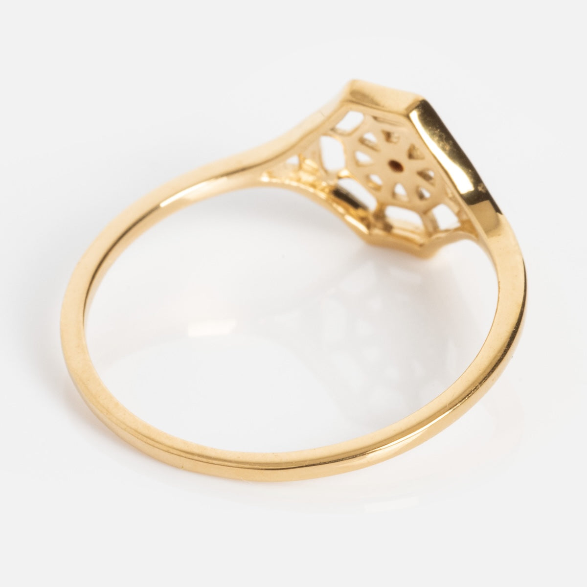 The Limited Edition Black Widow Garnet Spiderweb Ring features a thin gold band with an intricate geometric openwork design beneath the setting, shown against a white background.
