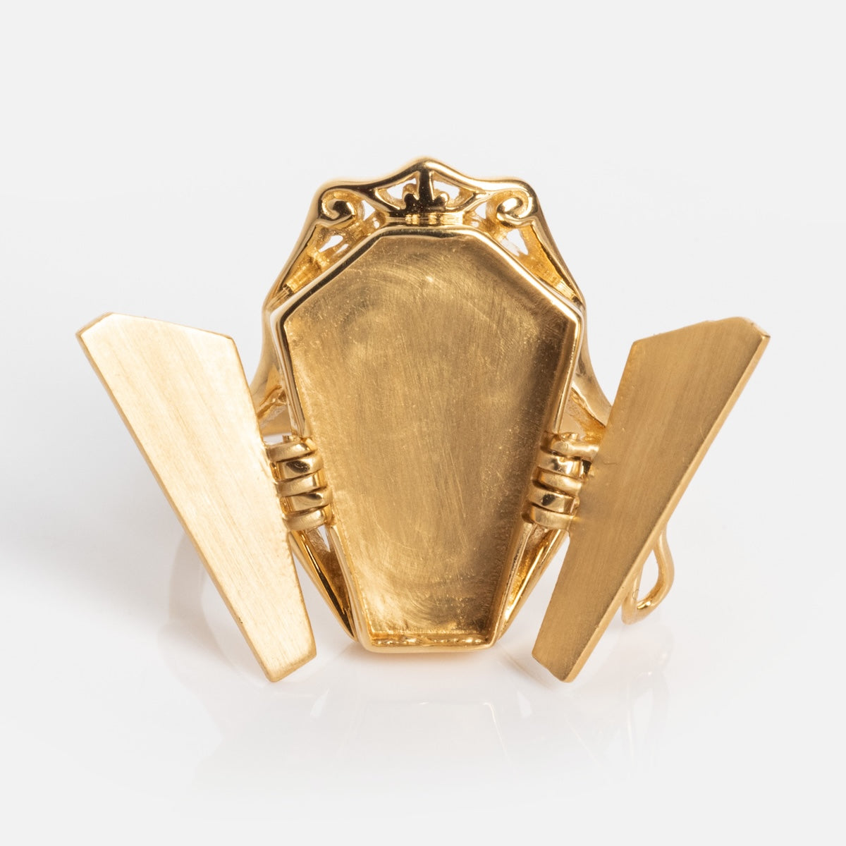 The Limited Edition Til Death Do Us Part Poison Ring is a gold coffin-shaped ring with hinged doors on both sides that open slightly to reveal the plain, closed coffin surface and decorative detailing on top.