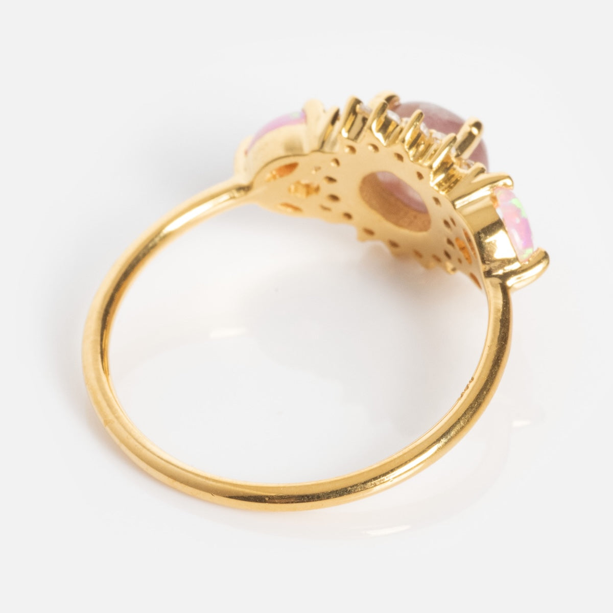 The Pink Opal and Cats Eye Moonstone Sunflower Ring showcases an ornate gold setting with a large central gemstone and two smaller opal stones on either side, viewed from the back against a white background.