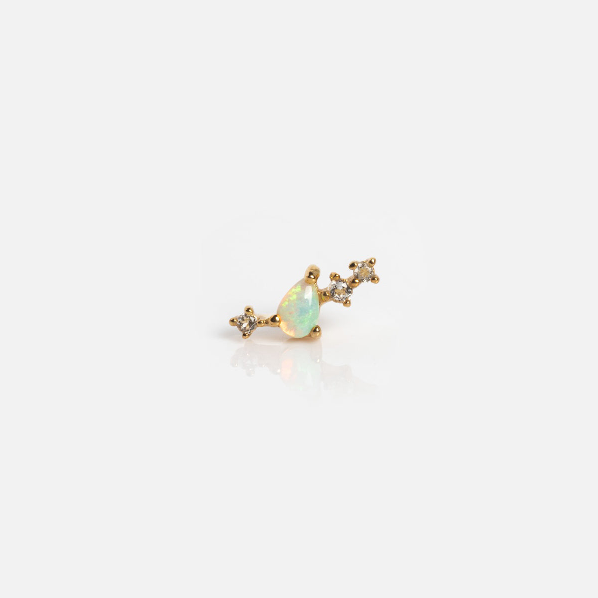 The Solid Gold Opal Constellation Flat Back Studs feature a small gold earring with a teardrop-shaped opal center and three clear gemstones clustered on each side, shown against a plain white background.