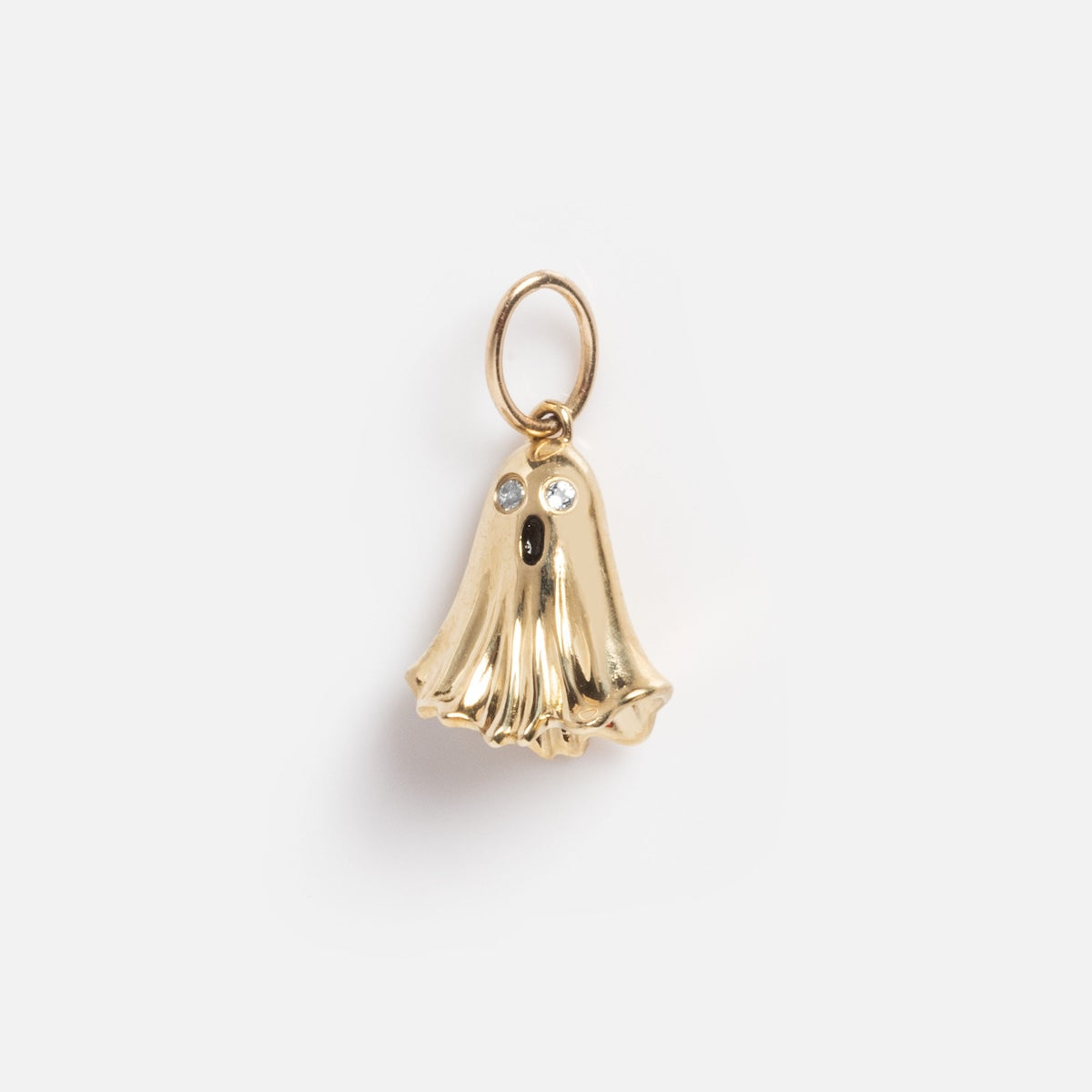 The Limited Edition Solid Gold Halloween Superstitions Charm features a small gold ghost-shaped pendant with two clear gemstone eyes, an open mouth, and a gold loop for hanging, shown on a plain white background.