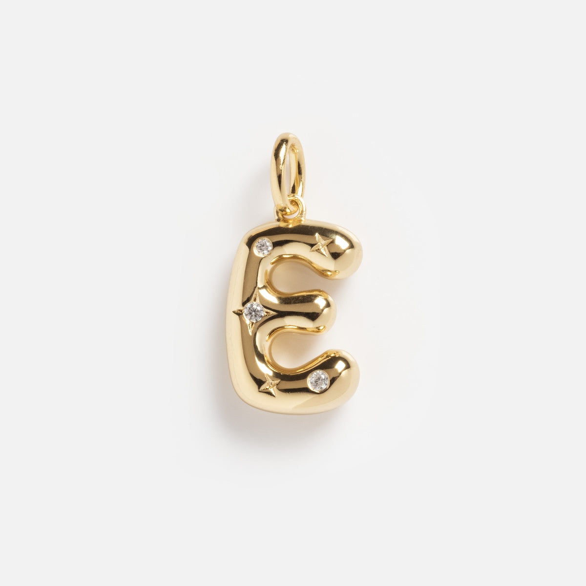 The Star Crossed Celestial Bubble Letter Charm is a gold pendant shaped like the letter E, featuring star accents and sparkling clear gemstones, shown on a plain white background.