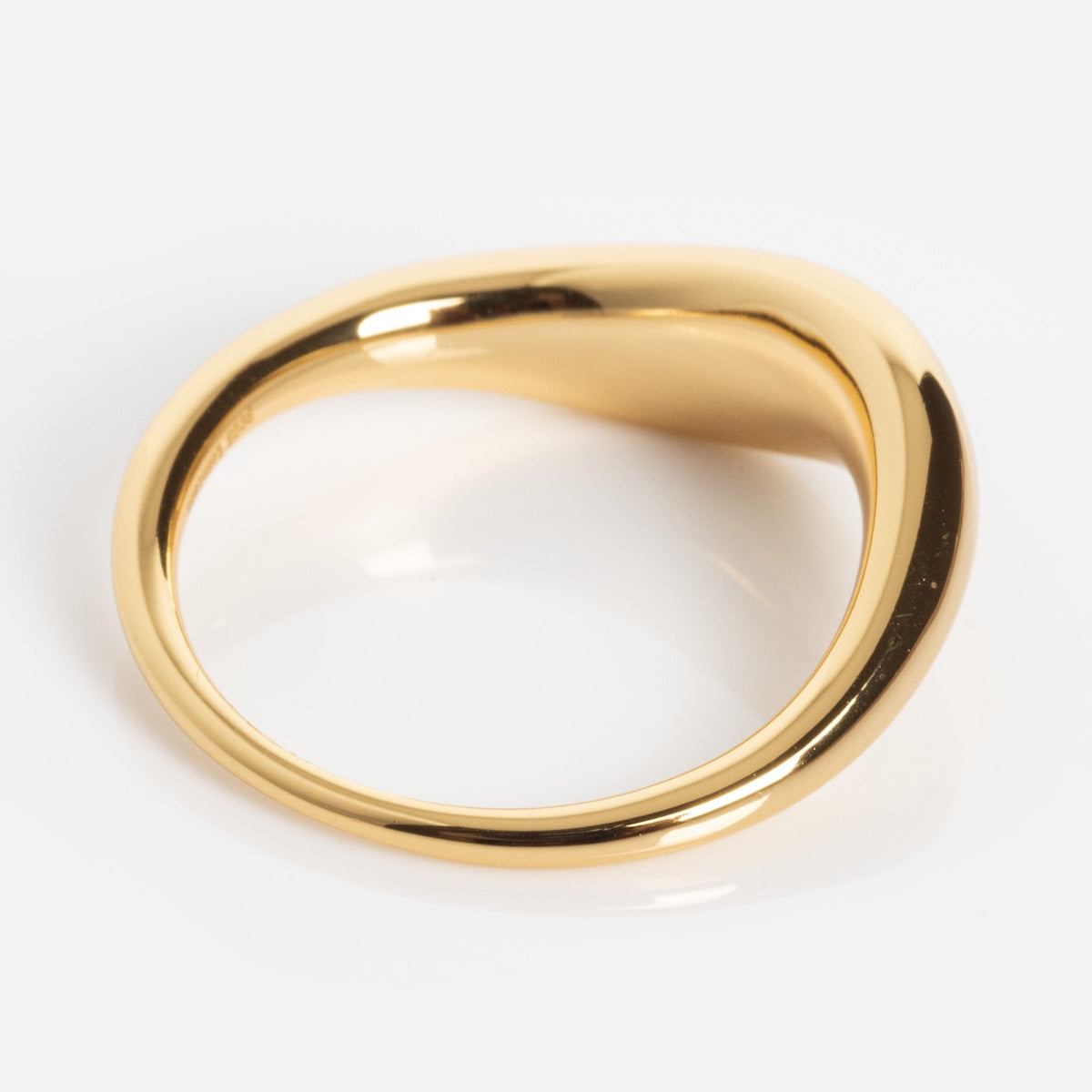 The Opal Dreamers Wave Ring features a shiny gold finish with a smooth, wavy, and asymmetrical design, displayed on a white background.